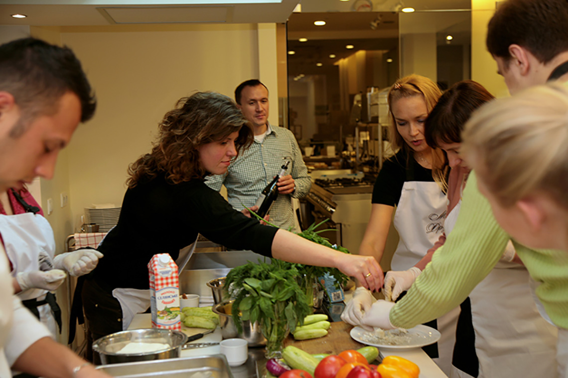 Участники учатся готовить блюда греческой кухни. Кулинарный тимбилдинг для Marfin Bank.